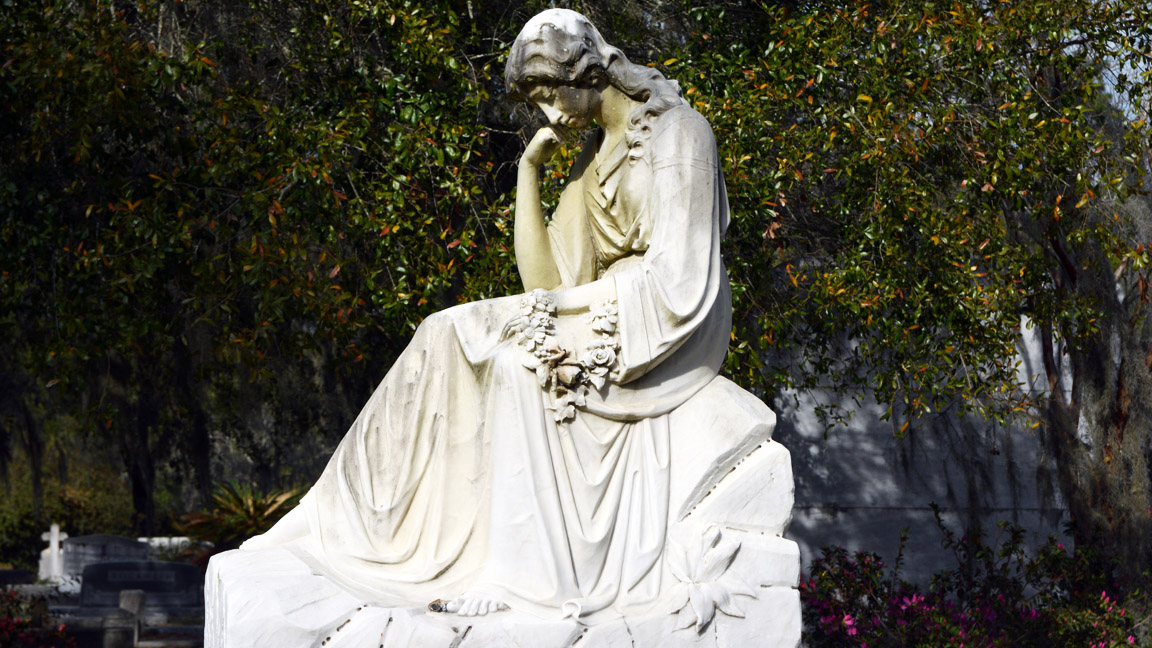 Photograph of the Theus Mausoleum at Bonaventure Cemetery, featuring its classical stone architecture amid scenic cemetery grounds